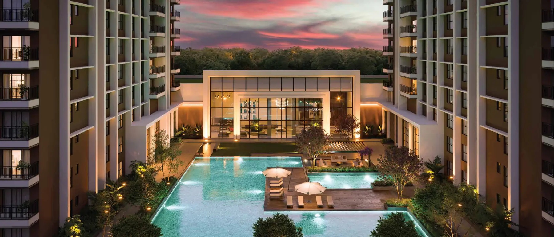 Twilight view of the resort-style swimming pool and clubhouse courtyard between the towers