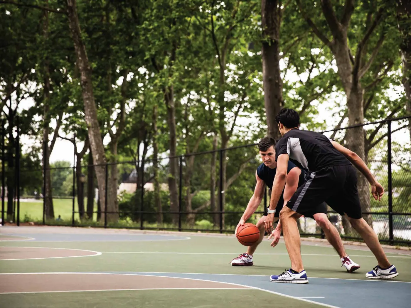 Residents playing basketball on the sports court