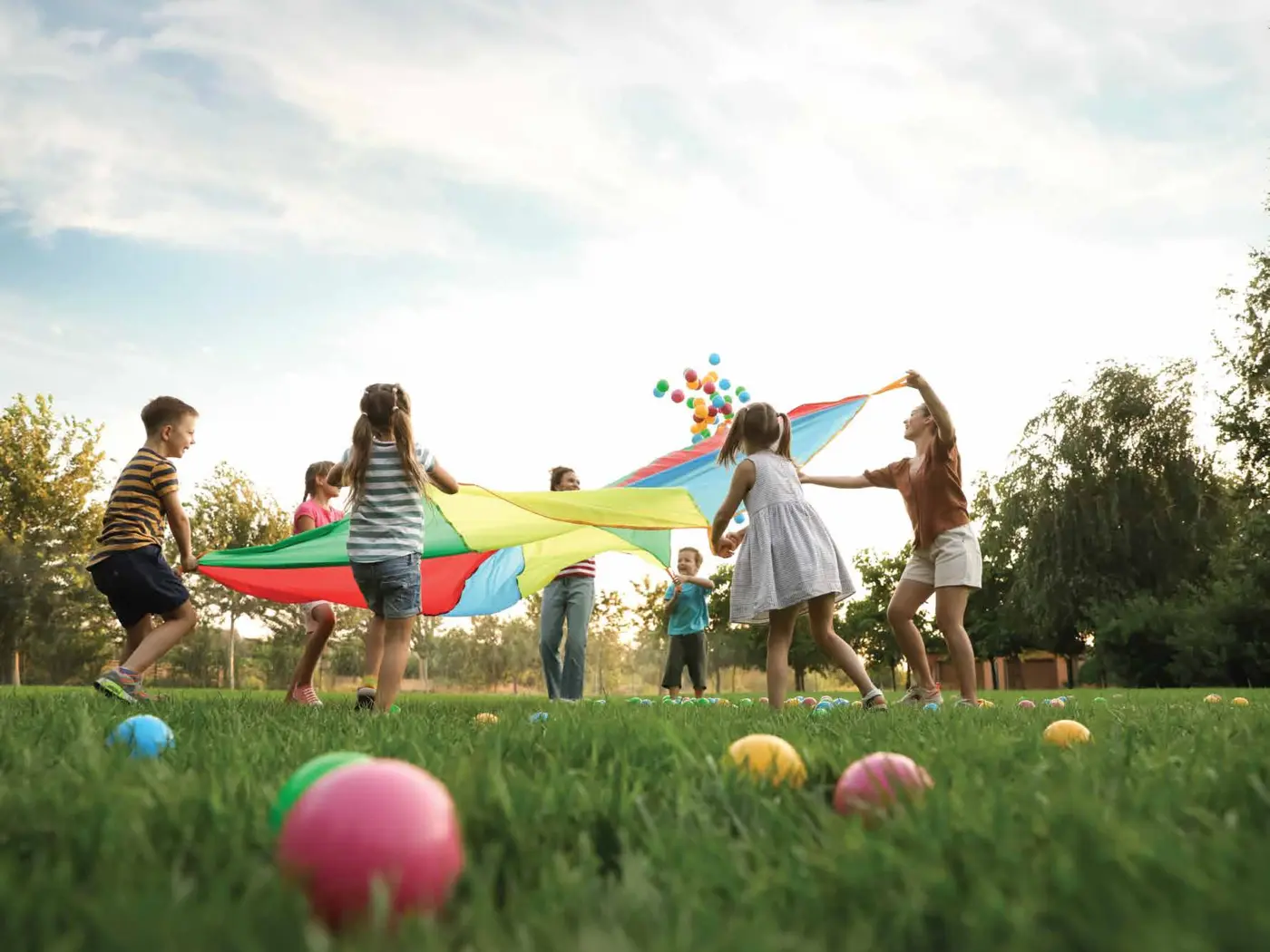 Children playing on the open lawn with family
